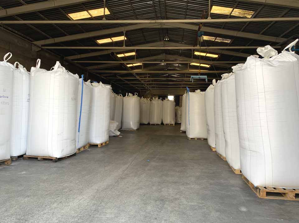 Blick in eine Halle gefüllt mit recycelten Granulaten und Mahlgütern, Recycelte Kunststoffe für den Handel auf dem Gelände einer Recycling Fabrik