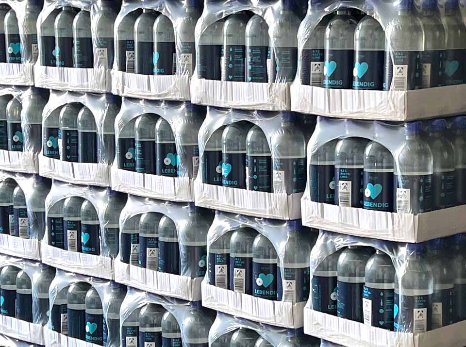 Palette mit Mineralwasser in recyceltem Plastik, Kartons mit PET Flaschen aus recyceltem Kunststoff, lebenmittelecht recycelter Kunstoff für Getränke